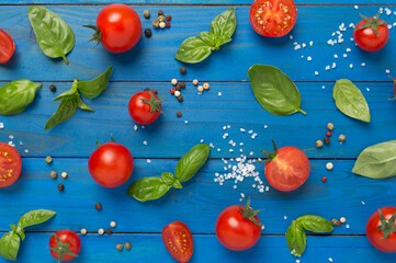 Fresh tomatoes, basil, sea salt and spices on wooden background, top view