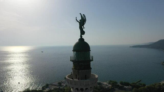Sunset view of Victory Lighthouse in Trieste, Italy. Iconic Faro della Vittoria illuminated by the golden hues of a summer evening.
