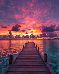 Fototapeta premium A scenic view of a wooden pier stretching out into the ocean under a stunning sunset sky filled with vibrant colors, providing a sense of peace and tranquility.