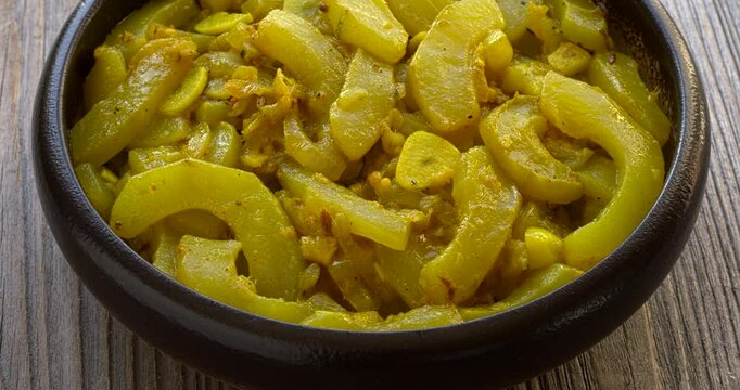 Homemade zucchini curry with tomatillo, garlic, onion and spices. Table spin.