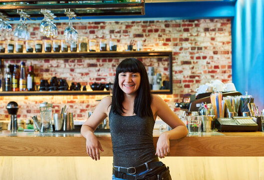 Small business, confident or portrait of happy woman at pub as female bartender in service industry. Entrepreneur, friendly waitress or proud barista in bar with smile ready to serve drinks in Spain