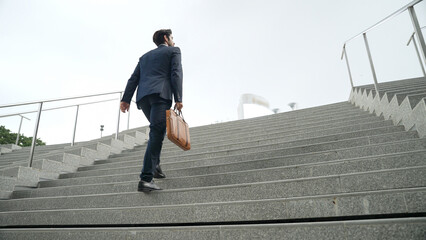 Top view of smart business man walking up stairs with bag in the hand. Professional project manager...