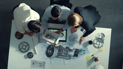 Top down view of skilled engineer working together while looking at jet engine. Aerial view of...