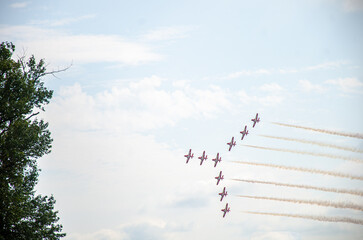 A formation of nine aircraft performing display and aerobatics