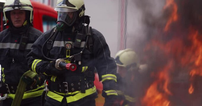 Firefighters fight the fire flame to control fire not to spreading out. Firefighter industrial and public safety concept. Traffic or car accident rescue and help action. 