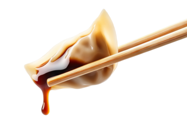 Delicious dumpling held with chopsticks, dripping soy sauce, cut out