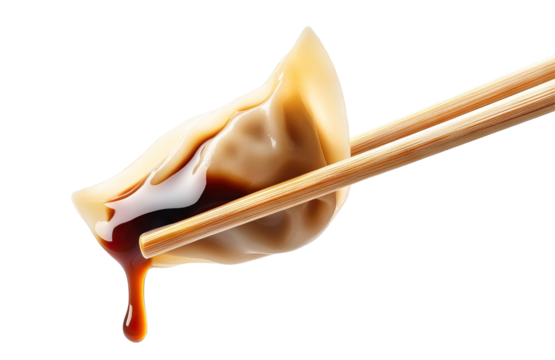 Delicious dumpling held with chopsticks, dripping soy sauce, cut out