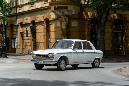 Classic french auto Peugeot 204 in white color is driving Subotica, Serbia, 09.06.2024