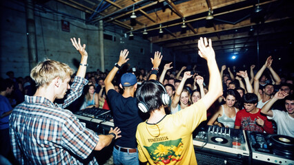 Ecstatic dj and his friends with raised arms enjoying music at vibrant nightclub