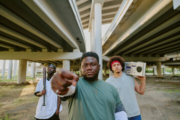 Multiracial bad guys looking at camera while partition on street together