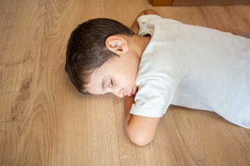 Above of an adorable child taking a nap lying on the floor