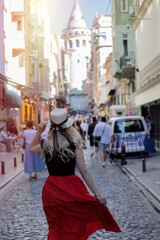 
Young woman in hat enjoying the view of Galata tower, Istanbul, Turkey