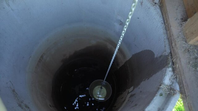 Fetching water from well by hand, fresh pure drinking mineral water.