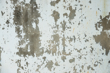 A wall with a lot of peeling paint and a lot of cracks