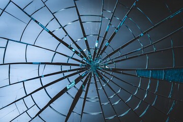 Cracked glass surface with blue and black shades, intricate patterns and fissures