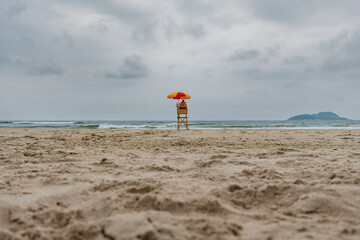 Beach lifeguard in the middle of the beach on a cloudy day and no people on the sea. Tombo beach, Guaruja - SP, Brazil.