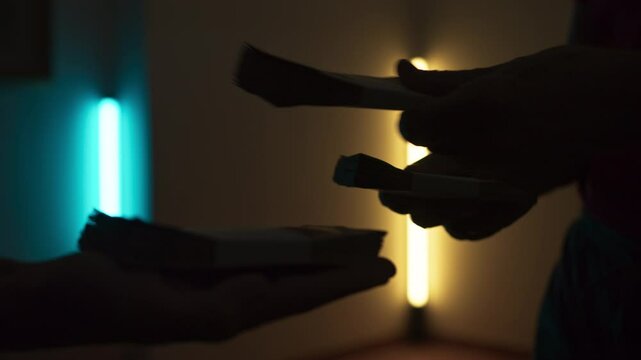 Silhouette Of Hands Passing Wad Of Corrupt Money