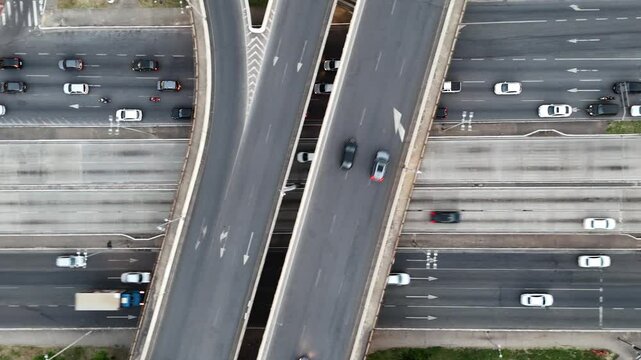 Vista a&eacute;rea do tr&acirc;nsito em avenida e viaduto. Drone faz movimento de deslocamento lateral acompanhando os ve&iacute;culos