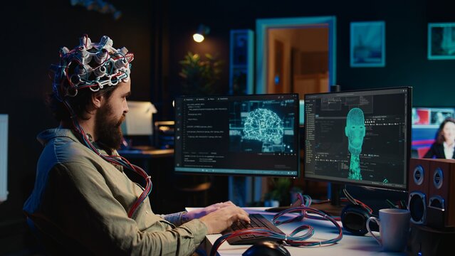 Computer engineer using EEG headset, starting mind upload process using brain machine interface. Man using neuroscientific device to transfer consciousness into cyberspace, typing code, camera B