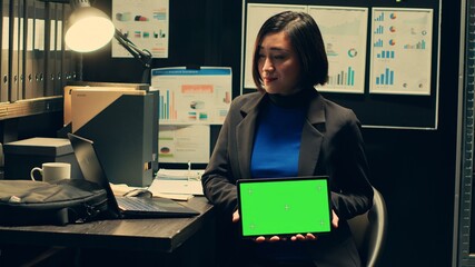 Private detective using tablet showing greenscreen template in incident room, working with witness...