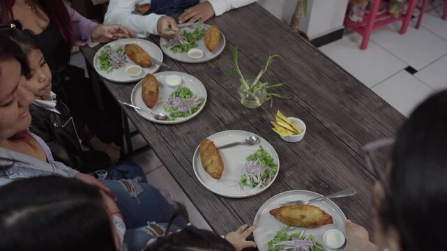 Family enjoying traditional peruvian stuffed potatoes together