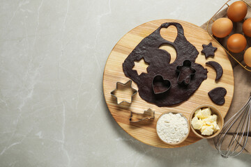Fototapeta premium Raw dough, cookie cutters and ingredients on grey marble table, top view. Space for text