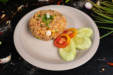 Golden brown fried rice with a side of fresh cucumber and tomato – a classic dish for any meal.