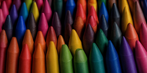 Dicht gedrängte farbige Wachsmalstifte, spitz zulaufend, in einem dynamischen und lebendigen Farbverlauf angeordnet, ideales Material für kreative Kunst- und Bastelprojekte