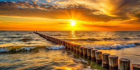 Golden sunset over the ocean with wooden breakwater