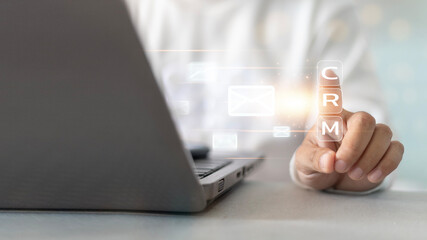 A person is pointing at CRM on a laptop