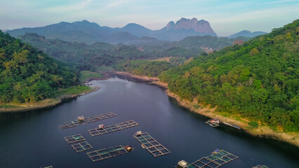 Aerial view of Jatiluhur reservoir with floating house. Scenic view of lake and mountains against sky