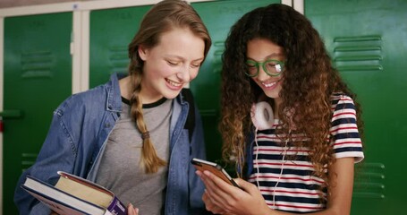 Students, girls and phone at high school locker for social media, funny meme or reading post on internet. Friends, teenager or youth laugh on mobile for chat, e learning and online resources or books - Powered by Adobe