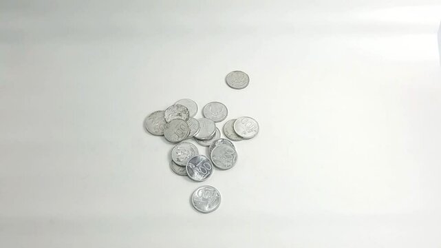 The scattered Rupiah coins symbolize the importance of financial planning and managing diverse resources for long-term economic stability and security.