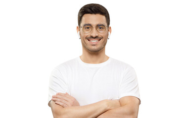 Obraz premium Young handsome man wearing white t-shirt, round glasses and wireless earphones, standing with crossed arms, smiling