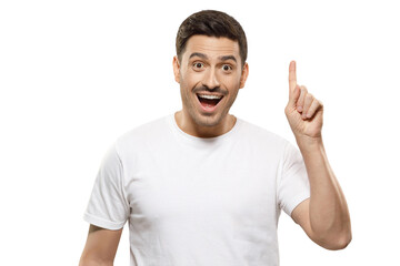 Young man in white t-shirt pointing up with his finger feeling excited with open mouth, showing benefit of commercial offer