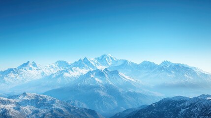 Obraz premium A panoramic view of a snow capped mountain range under a clear blue sky, perfect for themes of adventure and inspiration with ample copy space.