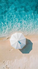 Naklejka premium Aerial View of a Lone Beach Umbrella in a Tranquil Summer Paradise