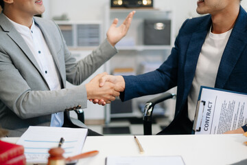 Asian business team and lawyers discussing contract papers sitting at the table. Concepts of law,...