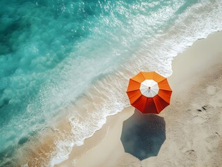 Obraz premium Overhead View of Vibrant Orange Beach Umbrella on Serene Turquoise Ocean