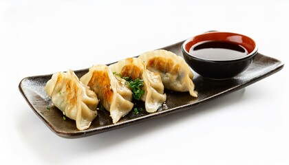 Japanese fried gyoza dumplings with soy sauce on white background