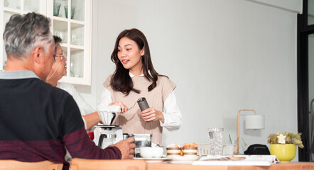 Fototapeta premium Asian family, consisting of a mother, father, and daughter, talking together in morning and prepare breakfast for parent moment of bonding in the kitchen area of their home.