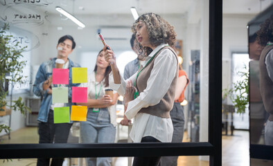 Group of young Asian professionals collaborating presentation project meeting in a modern office. Brainstorming innovative ideas for a new business venture.
