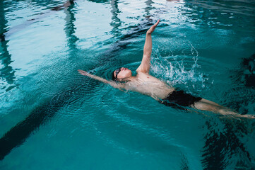 Professional Asian male swimmer swimming freestyle in pool