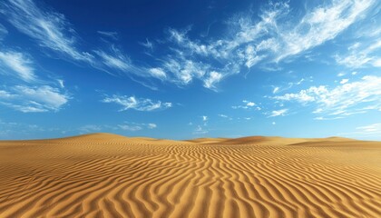 Naklejka premium Rippled Sand Dunes Beneath a Blue Sky With Wispy Clouds