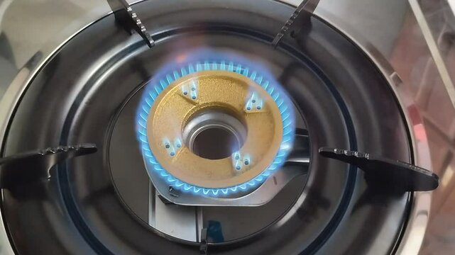 blue flame burning from a gas stove with a yellow burner made of iron. Stove fuel uses LPG