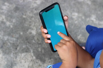 Close-up of a hand using a smartphone with a blue screen.