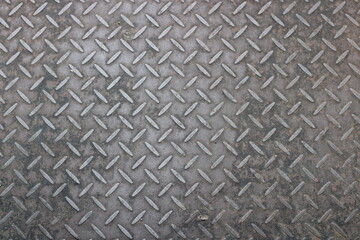 Closeup of a rusty diamond plate surface.