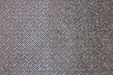 Close-up of a rusty metal surface with a diamond pattern.