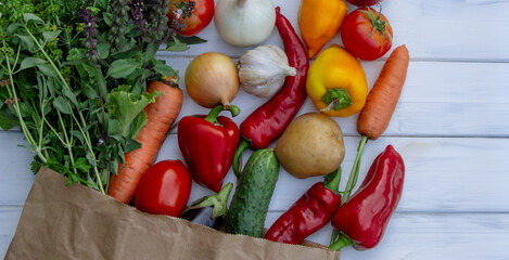 fresh vegetables and paper bag on white wooden background. Selective focus