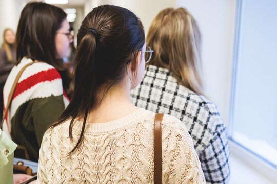 Group of students and school pupils in a science museum exhibition, excursion tour with guide, a docent with a tourist visitors, school field trip, attendees of technical museum exposition gallery
